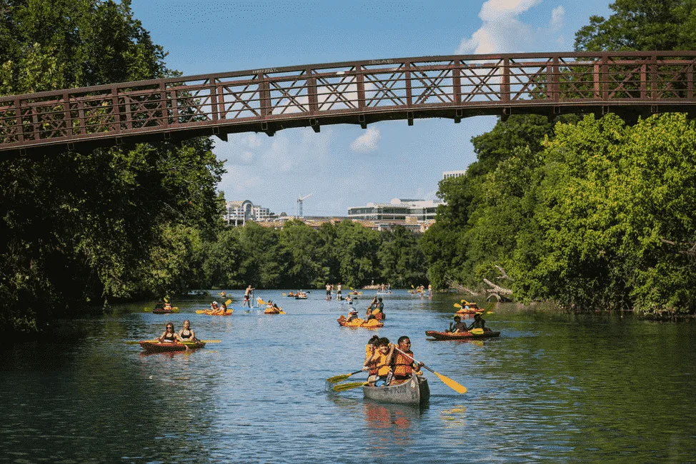 Kayakers paddling on Lady Bird Lake with the Austin skyline